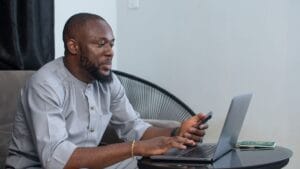 Nigerian applicant using a laptop to log in to the CDCFIB Login Portal for recruitment updates and shortlist checks.