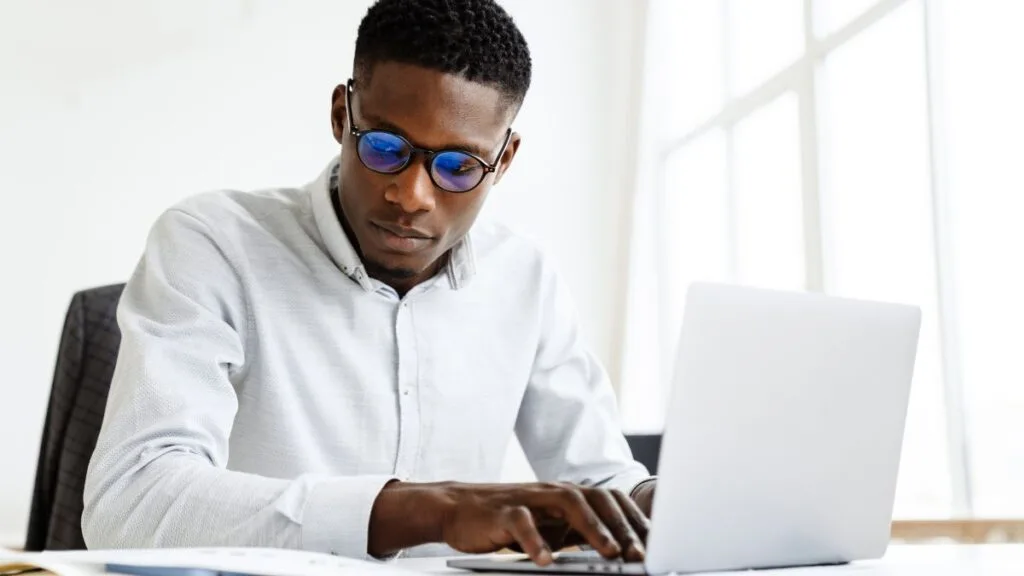 South African student preparing NSFAS requirements and documents for the 2026 application using a laptop at home