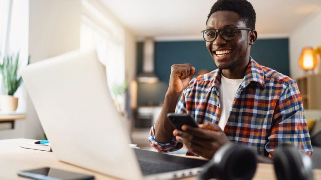 South African student using a laptop to complete an NSFAS status check at home