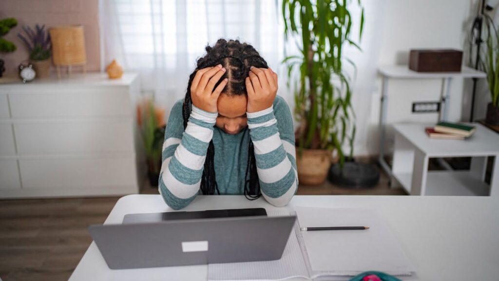 African student looking worried at laptop after missing scholarship opportunity